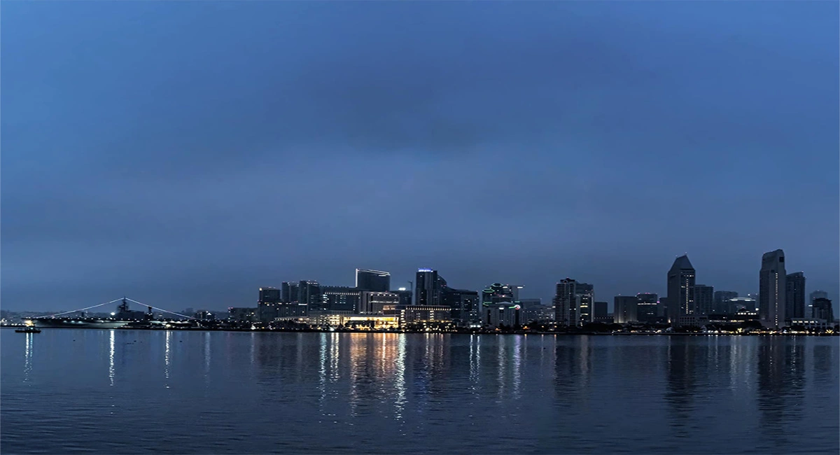 Downtown San Diego skyline at blue hour with the USS Midway and the city lights reflected on the bay, the broader San Diego region served by James Martial Arts Academy from East County El Cajon